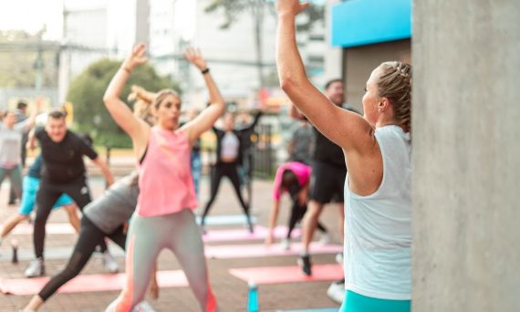 a group of people doing yoga outside on a sunny day